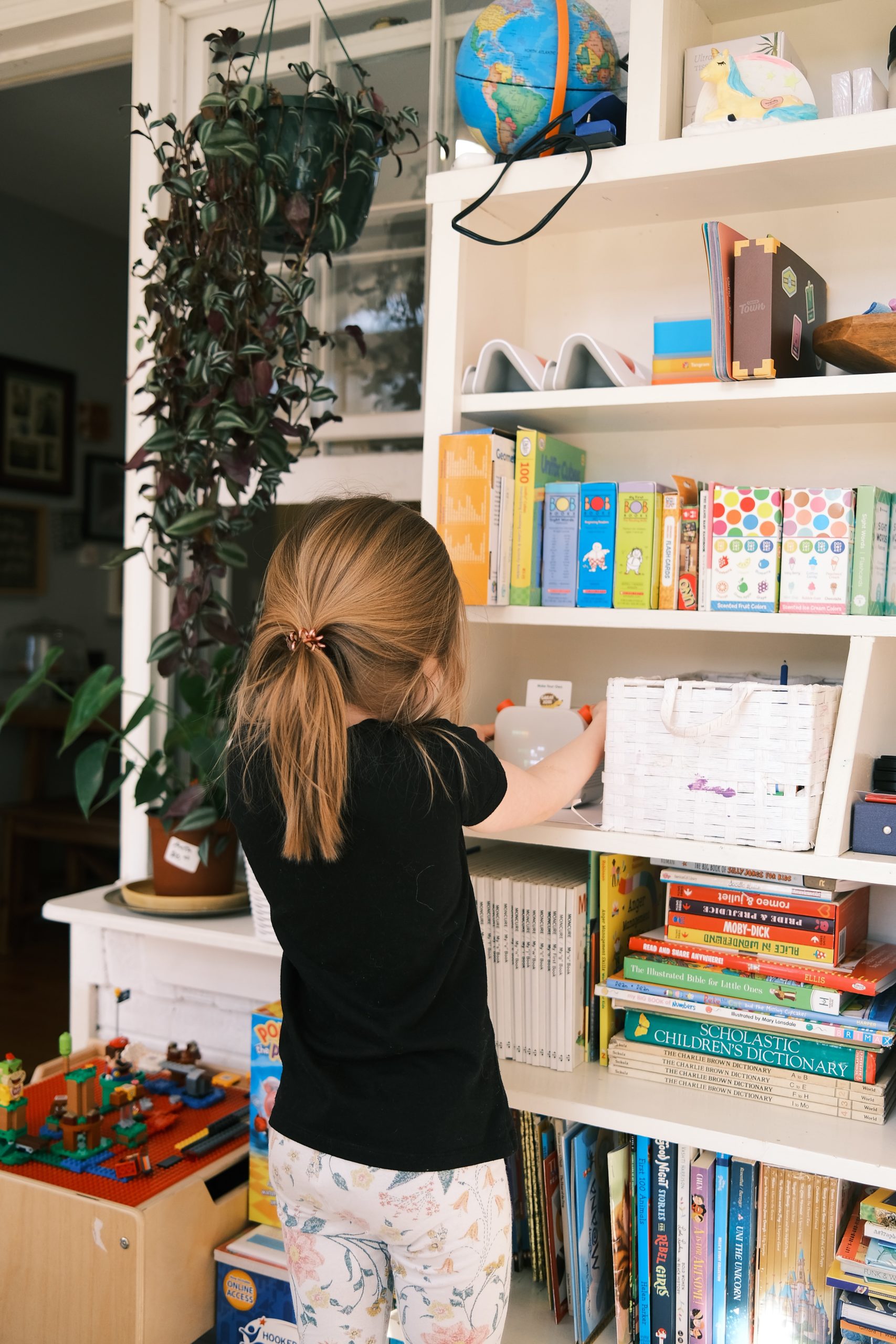 child organizing bookcase
