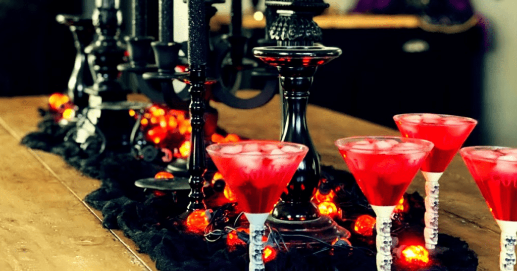 blood red martini's on a table with black candleholders